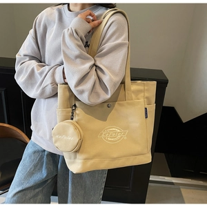 Détail du sac cabas en toile beige avec broderie du logo KeFeier et petit porte-monnaie