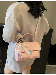 Chic pink glossy square crossbody bag with pearl lace bow charm on model