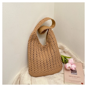 Detail of hand-woven crochet shoulder bag with intricate cutout texture and warm beige tones