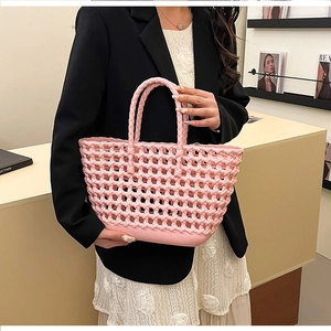 Detailed view of pink woven hollow beach basket with braided handles for summer vacation