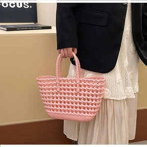 Detailed close-up of pink hollow-out woven texture on silicone beach jelly handbag