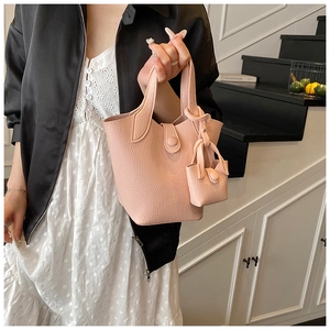 Pink lychee texture bucket bag with a mini pouch charm and magnetic closure detail