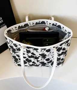Detailweergave van de cow print tote tas met ruime opbergruimte en ritsvak aan binnenzijde