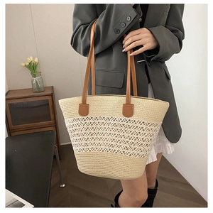 Detail of the woven tote bag featuring large diamond cutouts and brown leather handles