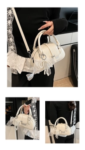 Detailed close-up of cream white leather handbag with pearl and bow charm accessories