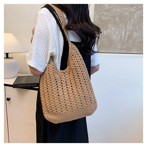 Detail of khaki crochet woven tote bag showing intricate hollow-out knit patterns and texture