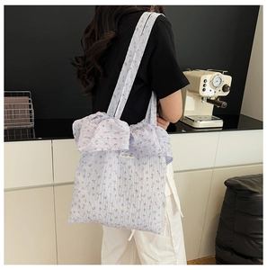 Vue détaillée du sac cabas floral lilas avec grand nœud et texture plissée