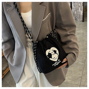 Detail der schwarzen Nylon-Beuteltasche mit Hunde-Stickerei und gestreiftem Gurt