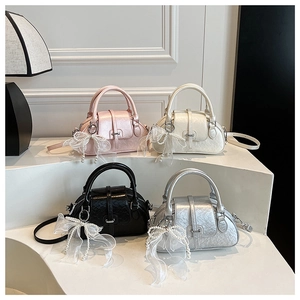 Detail of vintage boston bags in pink, white, black and silver with pearl bow charms