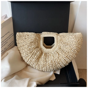 Detail of handmade woven straw tote bag with cutout handle on premium gift packaging