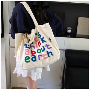 Detalle de bordado flocado colorido en un bolso tote de lona blanca usado