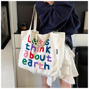 Detalle de las letras flocadas de colores Let's think about earth en bolso tote de lona