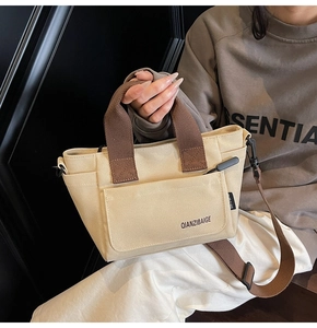 Detail van canvas crossbodytas in crème en koffie met verstelbare schouderband