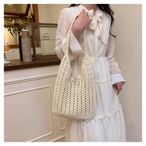 Detailed close-up of hollow crochet texture on cream cotton woven shoulder bag