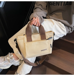 Detailopname van beige canvas draagtas met bruine riemen op een houten trap