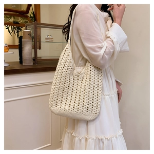 Chic beige crochet hobo bag featuring intricate hollow patterns and soft cotton weave