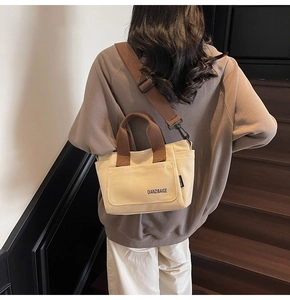 Detail van canvas crossbodytas met contrastvak en verstelbare brede schouderriem