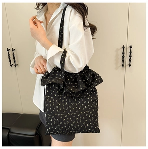 Détail du sac cabas floral noir avec volants plissés et bandoulière de transport