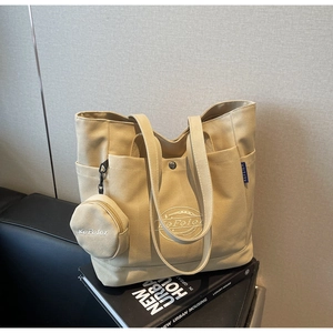 Détail du cabas en toile beige avec petite pochette ronde et poches multiples