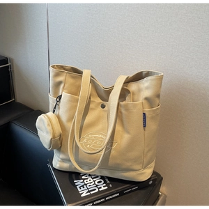 Détail du sac cabas en toile beige avec petite pochette ronde et imprimé du logo