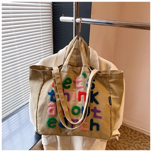 Detalle del bolso tote de lona caqui con bordado colorido let's think about earth