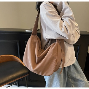 Close-up of brown large capacity tote bag showing soft nylon texture and crescent shape