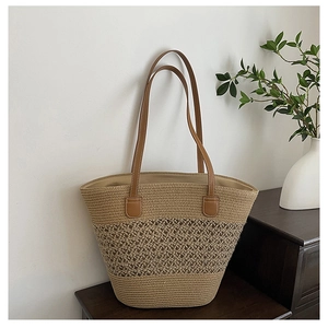 Close-up of woven straw tote bag with intricate patterns on a dark wooden cabinet