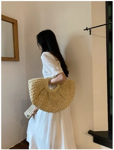 Close-up of handmade straw tote bag featuring detailed woven texture and circular handle