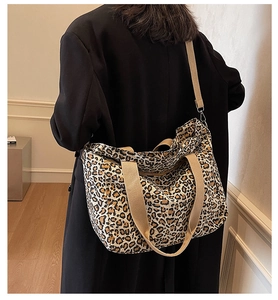 Detail of leopard print tote bag featuring sturdy khaki straps and adjustable shoulder belt