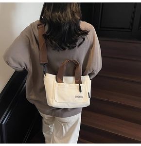 Chique beige canvas draagtas met bruine riemen over de schouder in een minimalistische set