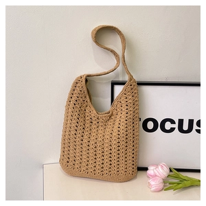 Detail of khaki crochet tote bag featuring intricate openwork patterns and a wide shoulder strap