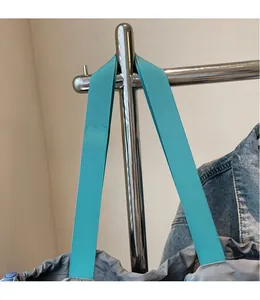 Detail of wide turquoise shoulder strap and drawstring closure on grey canvas tote bag