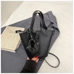 Detail of black lychee grain leather bucket bag with matching mini pouch and flap closure