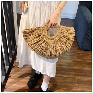 Close-up of hand-woven straw tote bag with round hollow handle and texture