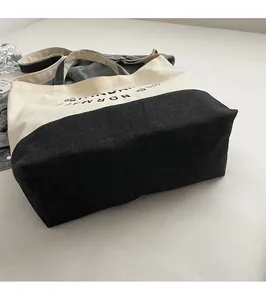 Détail du sac fourre-tout en toile bicolore noir et blanc avec lettrage imprimé