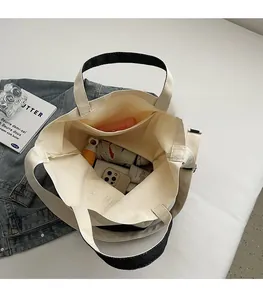 Vue intérieure du grand sac cabas en toile montrant l'espace de rangement et la poche latérale
