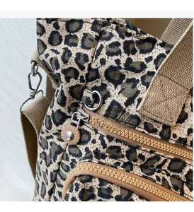 Detail of leopard print tote featuring silver hardware and smooth double zippers
