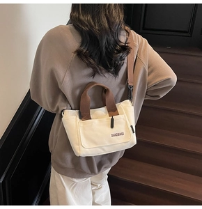 Minimalistische canvas crossbodytas in beige en bruin, achteraanzicht op het model