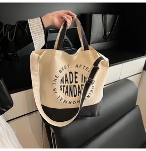 Détail du sac cabas en toile avec fond noir contrasté et bandoulière réglable