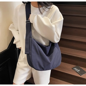 Detail of deep blue canvas tote bag featuring an adjustable strap for daily commute
