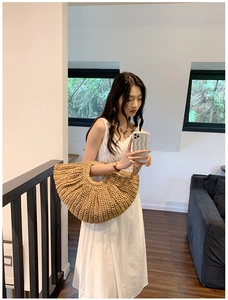 Detail of handmade straw beach bag with circular handle and tight woven texture