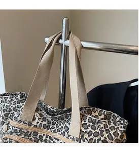 Detail of leopard print tote bag with reinforced handles and durable metal zipper