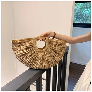 Close-up of semi-circle straw tote bag showing fine woven texture and square handle