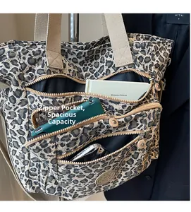 Detail view of large leopard print tote bag showing multiple zipper pockets and large capacity