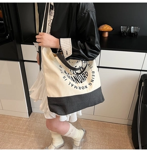 Détail du sac cabas en toile avec épissage bicolore et imprimé typographique