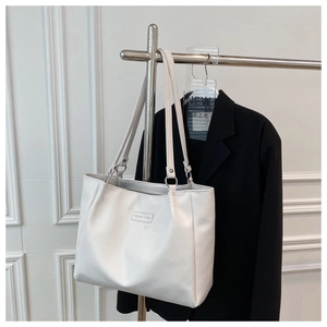 Close-up of a white leather tote bag with Fashion & Bag logo on a metal stand