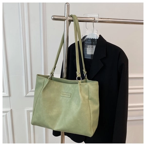Detail of light green tote bag leather texture with a Fashion & Bag logo label