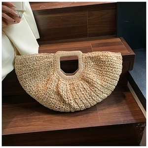 Macro shot of a handmade straw tote bag with woven textures on dark wooden stairs