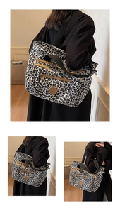 Detail of leopard print tote bag with multiple zippers and round logo patch