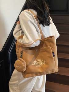 Grand sac fourre-tout en toile kaki avec petit porte-monnaie dans un cadre extérieur chic
